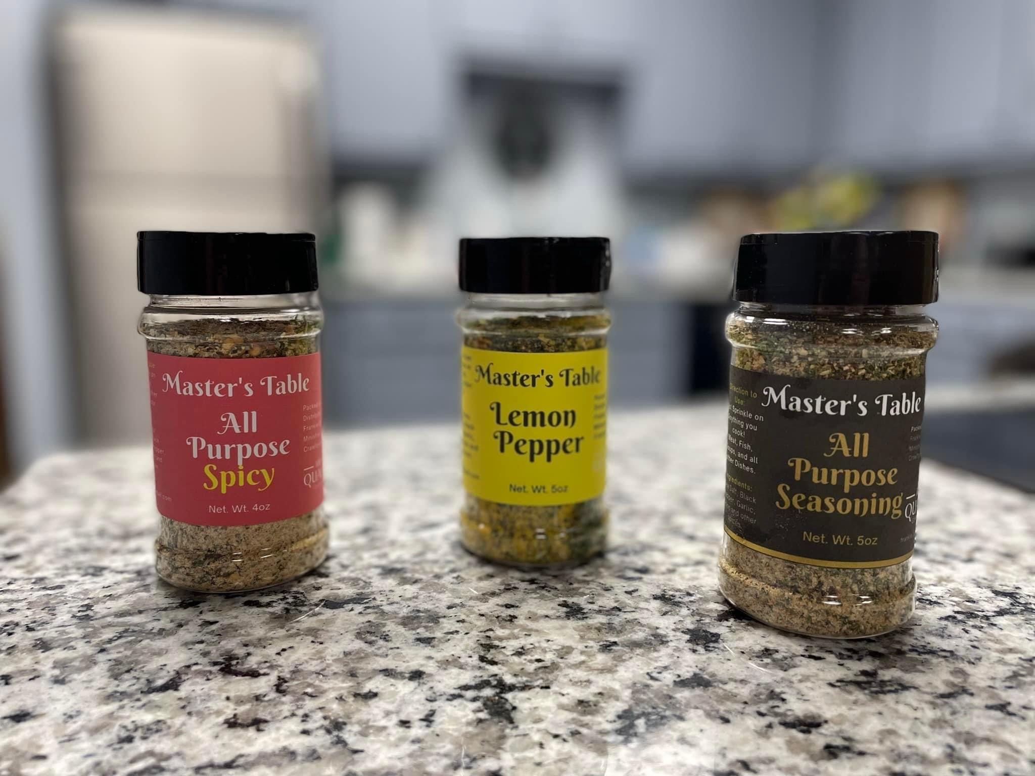 Three Master's Table seasonings on a kitchen counter: All Purpose Spicy, Lemon Pepper, and All Purpose Seasoning