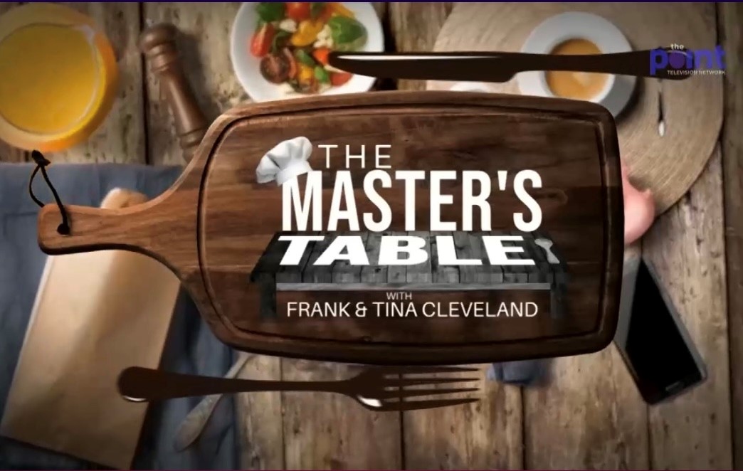 The Master's Table with Frank and Tina Cleveland logo on a wooden cutting board